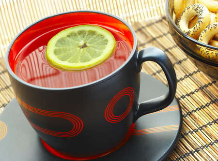 Cup of tea with a lemon on a table...の写真素材