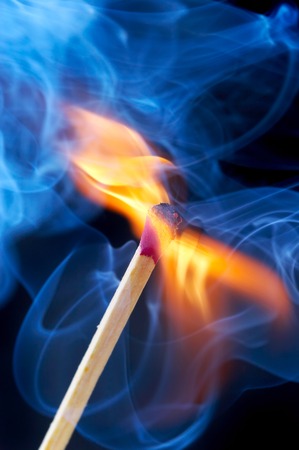 Photo of a burning match in a smoke on a black background...