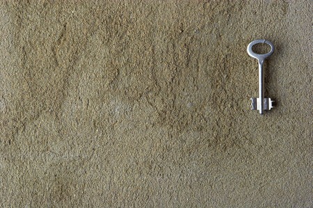 Iron key on a concrete wall の写真素材