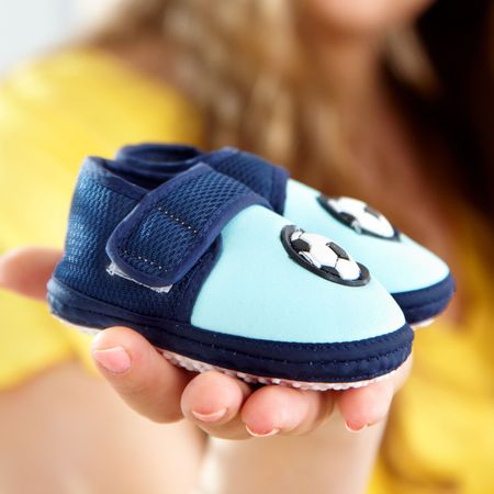 baby's bootee on a palm of future mum
