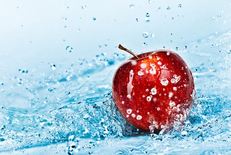 fresh water splash on red appleの写真素材