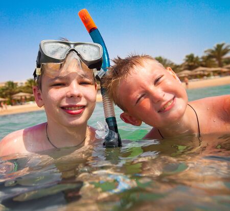 Two boys in the sea on a beachの写真素材