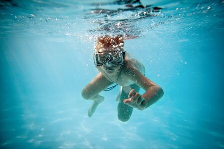 boy under water in poolの写真素材