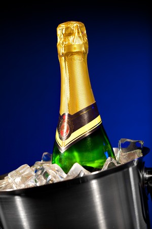 Champagne bottle in a bucket with ice on the darkの写真素材
