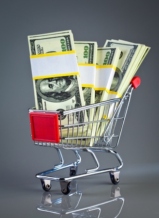 shopping cart and money on a grey backgroundの写真素材