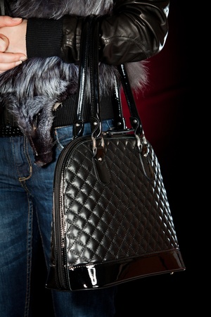 Female hand with a handbag on a dark backgroundの写真素材