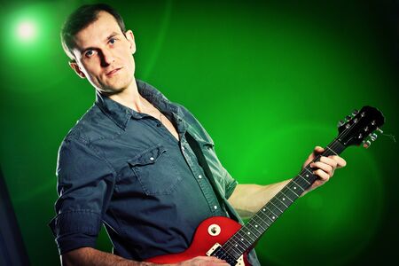 man with a guitar on a green backgroundの写真素材