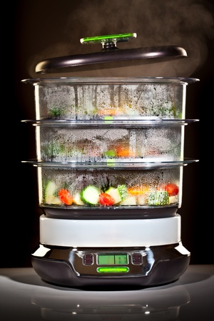 steam cooker with vegetables on a black backgroundの写真素材