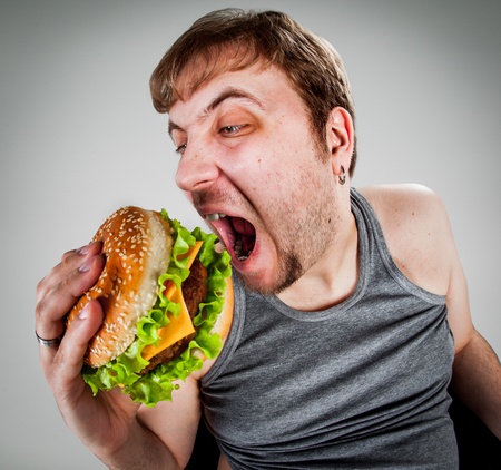 fat man eating hamburger seated on armchair fat man eating hamburger seated on armchair