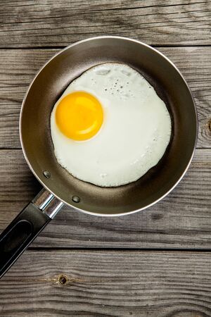 Fried eggs on a wooden table, breakfastの写真素材