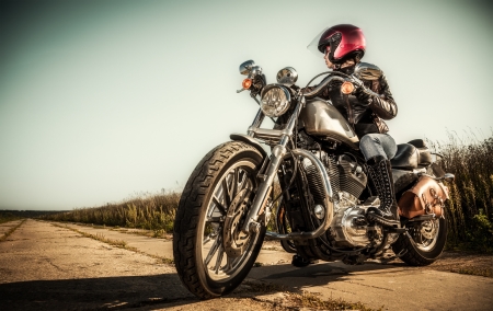 Biker girl sits on a motorcycleの写真素材