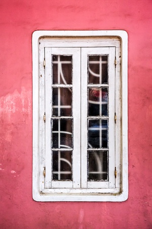 white window on an old red stucco wall backgroundの写真素材