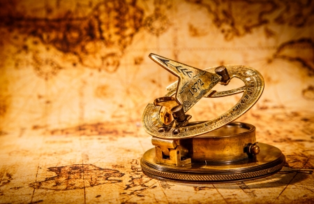Vintage still life. Vintage compass lies on an ancient world map.の写真素材