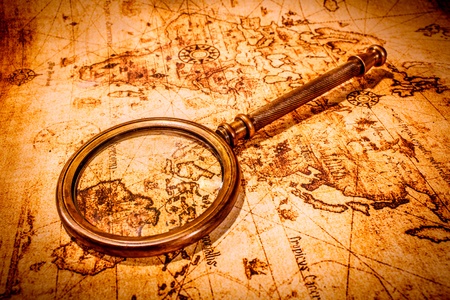 Vintage still life. Vintage magnifying glass lies on an ancient world mapの写真素材