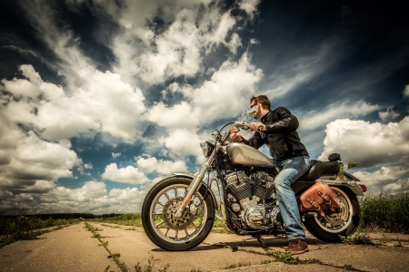 Biker in sunglasses and leather jacket on the roadの写真素材