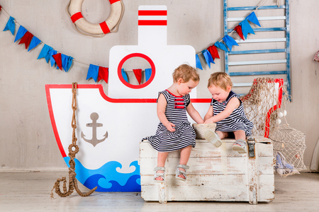 Two little girls play with seashells, sea theme.の写真素材
