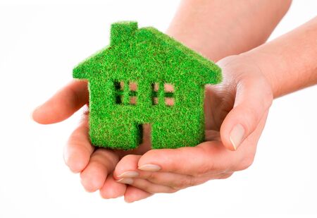 Grass home isolated on white background in human handsの写真素材