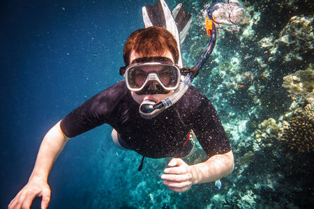 Snorkeler diving along the brain coral