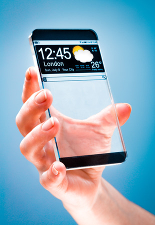 Futuristic Smart phone (copy space display) with a transparent display in human handsの写真素材