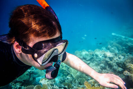 Snorkeler diving swimming under water.の写真素材