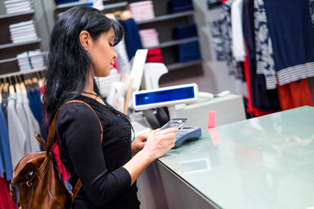 Girl pays to shop using mobile phone. NFC - Near field Communication. Mobile payment.の写真素材