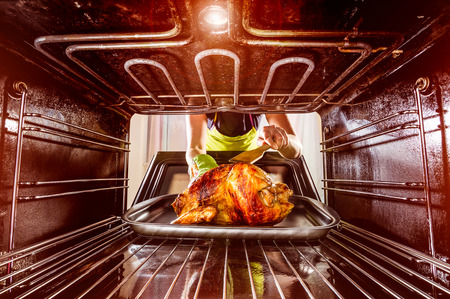 Housewife prepares roast chicken in the oven, view from the inside of the oven. Cooking in the oven.の写真素材