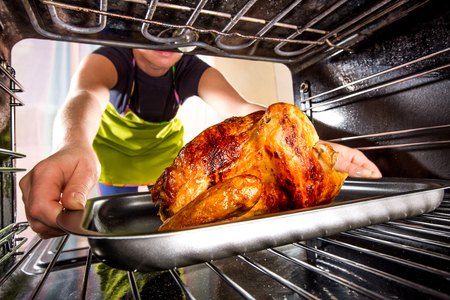 Housewife prepares roast chicken in the oven, view from the inside of the oven. Cooking in the oven.の写真素材