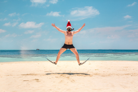 Christmas vacation - man in santa hat on the Maldives tropical beachの写真素材
