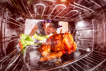 Funny Housewife overlooked roast chicken in the oven, so she had scorched , view from the inside of the oven. Housewife perplexed and angry. Loser is destiny!の写真素材