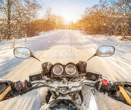 Biker rides on winter slippery road. First-person view.の写真素材
