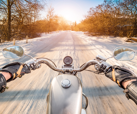 Biker rides on winter slippery road. First-person view.の写真素材