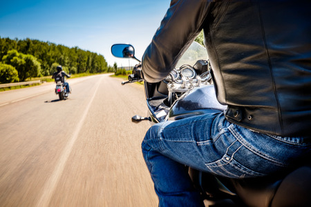 Bikers driving a motorcycle rides along the asphalt road (blurred motion). First-person view. Focus on the dashboard of a motorcycle Bikers driving a motorcycle rides along the asphalt road (blurred motion). First-person view. Focus on the dashboard of a motorcycle