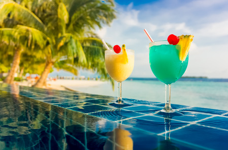 Cocktail near the swimming pool on the background of the Indian Ocean, Maldives.