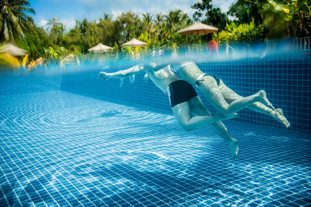 Couple floating in the pool on holiday views over the water and under water. Maldives.の写真素材