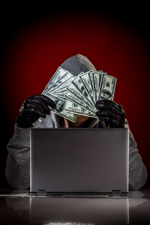 Hacker in a sunglasses with laptop.の写真素材