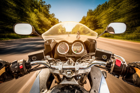 Biker driving a motorcycle rides along the asphalt road. First-person view. Biker driving a motorcycle rides along the asphalt road. First-person view.