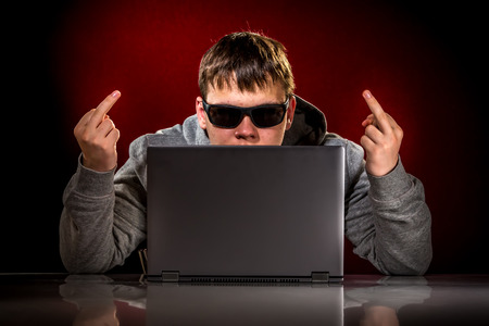 Hacker in a sunglasses with laptop.の写真素材