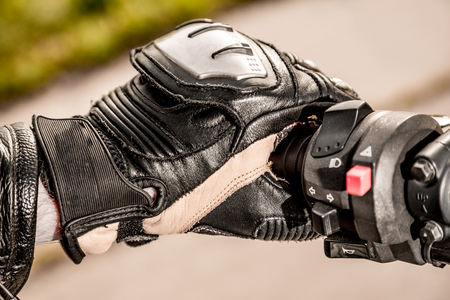 Human hand in a Motorcycle Racing Gloves holds a motorcycle throttle control. Hand protection from falls and accidents.の写真素材