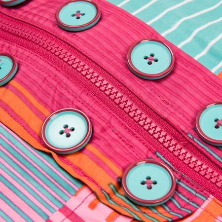 Close up zipper and button on a colorful background