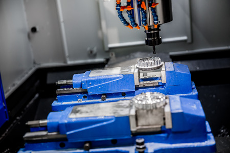 Metalworking CNC milling machine. Cutting metal modern processing technology. Small depth of field. Warning - authentic shooting in challenging conditions. A little bit grain and maybe blurred.の写真素材