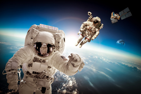 Astronaut in outer space against the backdrop of the planet earth. Elements of this image furnished by NASA.