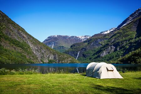 Camping. Holiday in Norway. Tourist tent on the shore of the lake.の写真素材