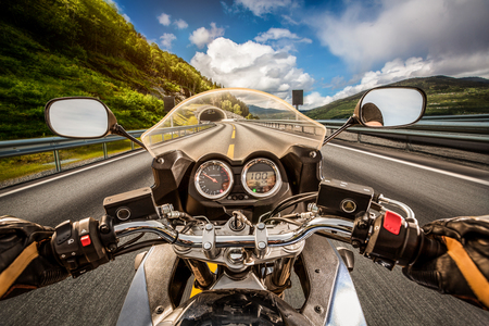Biker driving a motorcycle rides along the asphalt road. First-person view.の写真素材