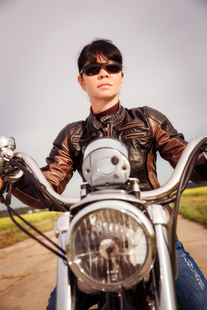 Biker girl in a leather jacket on a motorcycleの写真素材