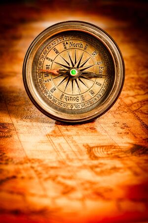 Vintage still life. Vintage compass lies on an ancient world map in 1565.の写真素材