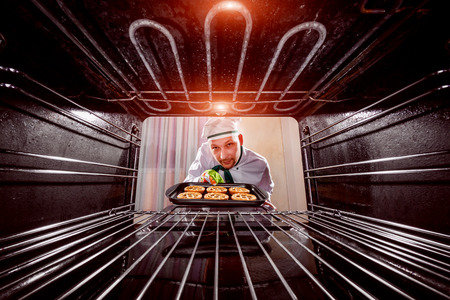 Chef prepares pastries in the oven, view from the inside of the oven. Cooking in the oven.の写真素材
