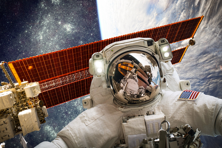 Astronaut in outer space against the backdrop of the planet earth. Elements of this image furnished...
