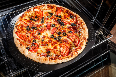 Appetizing pizza in the oven, Cooking in the oven.の写真素材