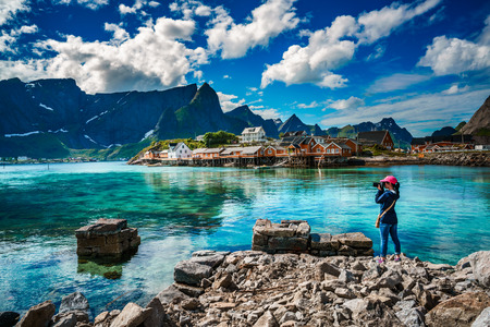 Nature photographer tourist with camera shoots Lofoten archipelago islands Norway. Beautiful Nature Norway.の写真素材