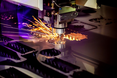 CNC Laser cutting of metal, modern industrial technology. Small depth of field. Warning - authentic shooting in challenging conditions. A little bit grain and maybe blurred.